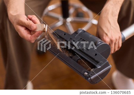 Hand cleaning vacuum brush bristles. Resolving debris from vacuum head regularly. Maintaining household appliances through routine cleaning of vacuum brush components Hand cleaning vacuum brush bristles. Resolving debris from vacuum head regularly. Maintaining household appliances through routine cleaning of vacuum brush components 136070685