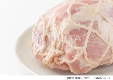Close-up of pork leg ham wrapped in string on a plate 136070704