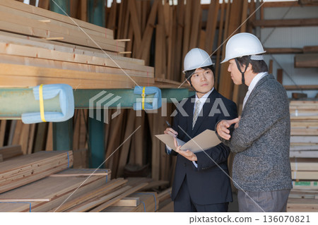 Men in suits looking at lumber at a lumberyard Men in suits looking at lumber at a lumberyard 136070821