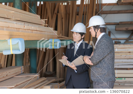 Men in suits looking at lumber at a lumberyard Men in suits looking at lumber at a lumberyard 136070822