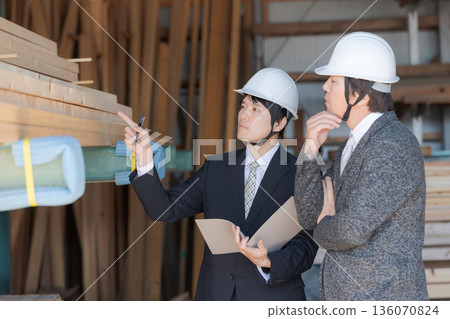 Men in suits looking at lumber at a lumberyard Men in suits looking at lumber at a lumberyard 136070824