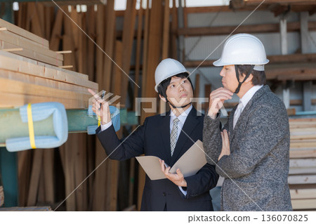 Men in suits looking at lumber at a lumberyard Men in suits looking at lumber at a lumberyard 136070825