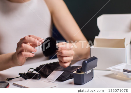 Foam windscreen attachment on lapel microphone. Behind scenes of professional beauty shoot setup. Behind scenes look at content creator preparing gear for filming Foam windscreen attachment on lapel microphone. Behind scenes of professional beauty shoot setup. Behind scenes look at content creator preparing gear for filming 136071078