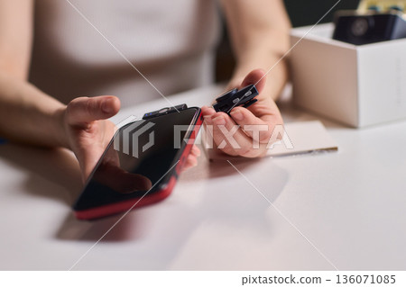 Lavalier attachment to phone for rapid interview recordings. Onsite interview preparation involving portable microphone and quick assembly tools in natural lighting conditions 136071085