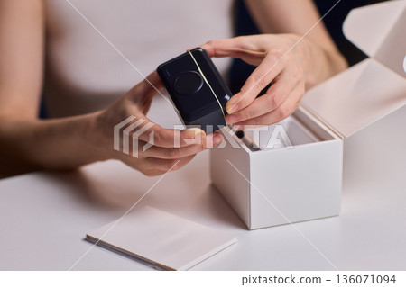 Professional microphone placement process. Technician carefully arranges microphone on desk. Precise setup of audio equipment for broadcasting or retail display 136071094