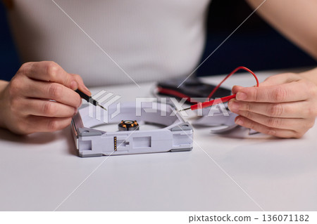 Meticulous technician conducts detailed inspection of fan wiring connectivity, Focused technician meticulously tests and inspects fan motor connections with precision and care 136071182