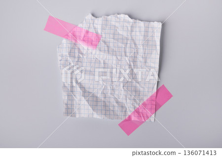 Crumpled grid paper note with torn edges fixed by pink adhesive tapes Crumpled grid paper note with torn edges fixed by pink adhesive tapes 136071413