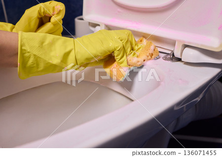 Professional cleaning in action, Detailed cleaning of toilet rim for sanitation and hygiene, Closeup of meticulous toilet rim cleaning for hygiene and thorough sanitation 136071455