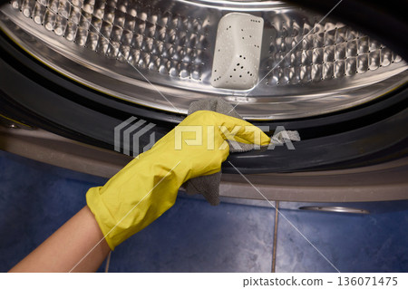 Using gloves to clean and protect gasket seals from mold, Thoroughly maintain gasket surfaces by sanitizing with cloth and hand wiping to prevent mold and moisture buildup 136071475