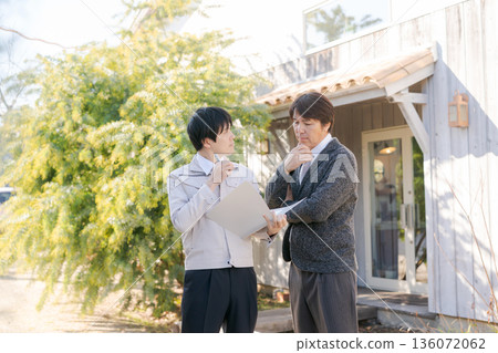 身著工作服的男人們在一棟時尚建築前交談。 136072062