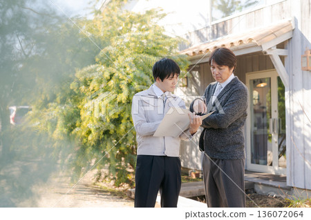 身著工作服的男人們在一棟時尚建築前交談。 身著工作服的男人們在一棟時尚建築前交談。 136072064