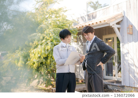 身著工作服的男人們在一棟時尚建築前交談。 136072066