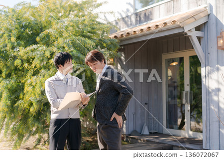身著工作服的男人們在一棟時尚建築前交談。 身著工作服的男人們在一棟時尚建築前交談。 136072067