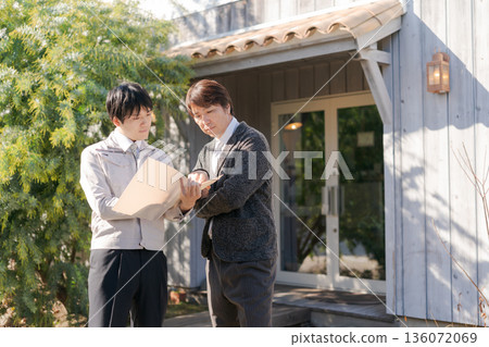 Men in work clothes talking in front of a stylish building 136072069