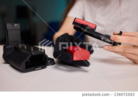 Camera power supply setup process, Connecting battery pack carefully into camera housing for filming, Unboxing and installing power source into camera in studio setting 136072083