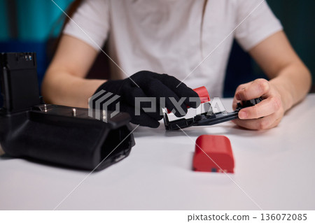 Camera power supply setup process, Connecting battery pack carefully into camera housing for filming, Unboxing and installing power source into camera in studio setting 136072085