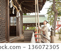 Senior woman praying at a shrine 136072305