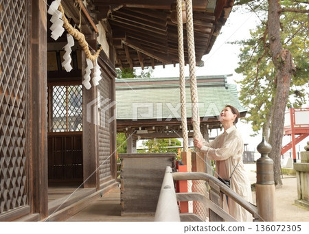 Senior woman praying at a shrine Senior woman praying at a shrine 136072305