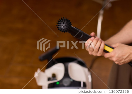 Household brushes examined closely, Two brushes analyzed in indoor setting, Person holding two black brushes inspecting bristle arrangement for household cleaning purposes Household brushes examined closely, Two brushes analyzed in indoor setting, Person holding two black brushes inspecting bristle arrangement for household cleaning purposes 136072336