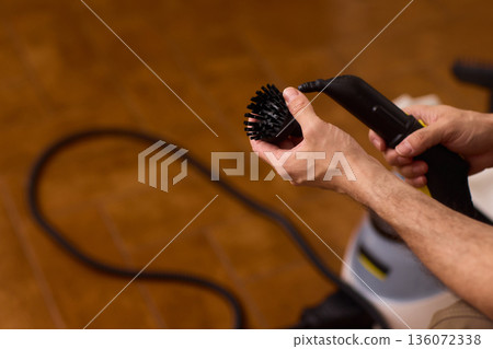 Household brushes examined closely, Two brushes analyzed in indoor setting, Person holding two black brushes inspecting bristle arrangement for household cleaning purposes Household brushes examined closely, Two brushes analyzed in indoor setting, Person holding two black brushes inspecting bristle arrangement for household cleaning purposes 136072338