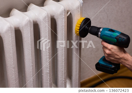 Radiator cleaning process, Metal radiator being cleaned with power brush in workshop, Effective deep cleaning of radiator using drill brush in home maintenance setting Radiator cleaning process, Metal radiator being cleaned with power brush in workshop, Effective deep cleaning of radiator using drill brush in home maintenance setting 136072423