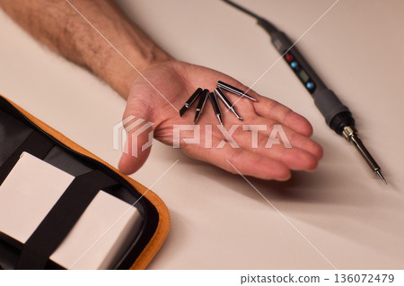 Detailed view of soldering iron and electronic components setup, Scene depicting meticulous preparation for circuit fixing and part assembly involving soldering tools Detailed view of soldering iron and electronic components setup, Scene depicting meticulous preparation for circuit fixing and part assembly involving soldering tools 136072479