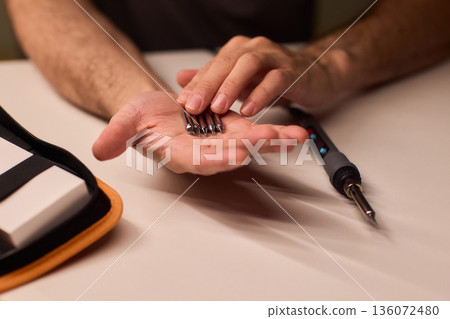 Detailed view of soldering iron and electronic components setup, Scene depicting meticulous preparation for circuit fixing and part assembly involving soldering tools Detailed view of soldering iron and electronic components setup, Scene depicting meticulous preparation for circuit fixing and part assembly involving soldering tools 136072480