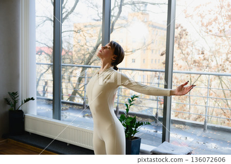 Woman practicing mindful stretching in yoga studio Woman practicing mindful stretching in yoga studio 136072606