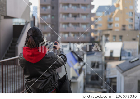 Back view of a woman taking a photo of Shinjuku Arakicho with her smartphone Back view of a woman taking a photo of Shinjuku Arakicho with her smartphone 136073030