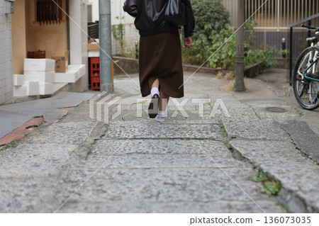 Back view of a woman walking on the cobblestone streets of Arakicho, Shinjuku Back view of a woman walking on the cobblestone streets of Arakicho, Shinjuku 136073035