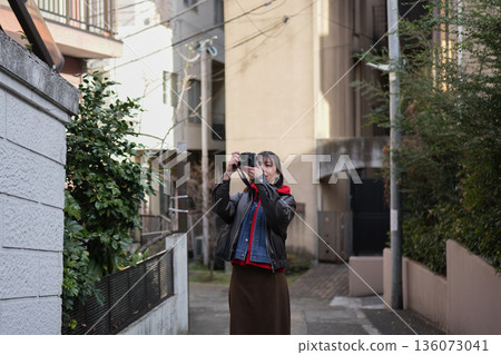 A woman strolling around Shinjuku Arakicho with a camera 136073041