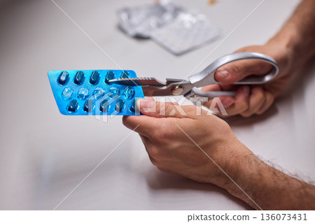 Precise scissors work with blister pack disposal focus, Engaged in cautious scissors cutting of blister pack on clean countertop emphasizing safety and responsible disposal Precise scissors work with blister pack disposal focus, Engaged in cautious scissors cutting of blister pack on clean countertop emphasizing safety and responsible disposal 136073431