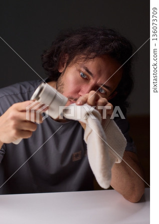 Close view of lint tool on wool, Man using lint roller to clean wool hat texture, Detailed scene of hand grooming fuzz from soft knitted wool hat with lint roller 136073709