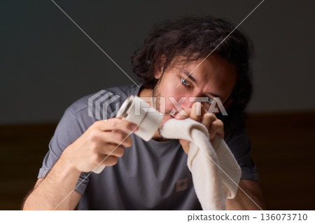 Close view of lint tool on wool, Man using lint roller to clean wool hat texture, Detailed scene of hand grooming fuzz from soft knitted wool hat with lint roller 136073710