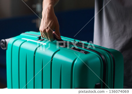 Secure suitcase with combo lock, Hands set combination on teal suitcase with textured surface, Closeup of hands adjusting numeric lock on stylish teal travel suitcase Secure suitcase with combo lock, Hands set combination on teal suitcase with textured surface, Closeup of hands adjusting numeric lock on stylish teal travel suitcase 136074069