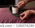 Close view of lint tool on wool, Man using lint roller to clean wool hat texture, Detailed scene of hand grooming fuzz from soft knitted wool hat with lint roller 136074280