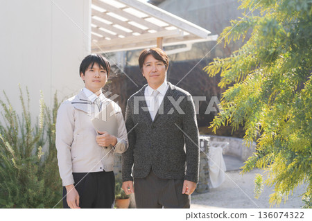 Smiling man in front of a house 136074322
