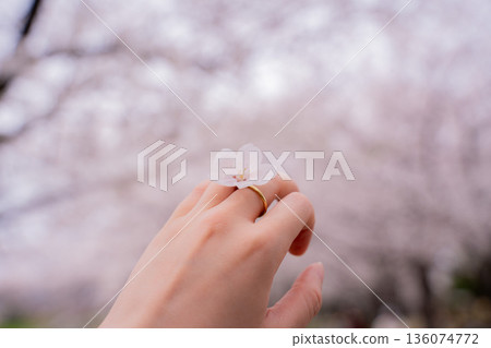 女人的手戴著一枚繡有櫻花圖案的金戒指 136074772