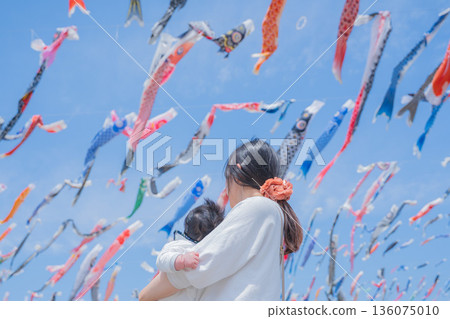 Mother and baby looking up at carp streamers Mother and baby looking up at carp streamers 136075010
