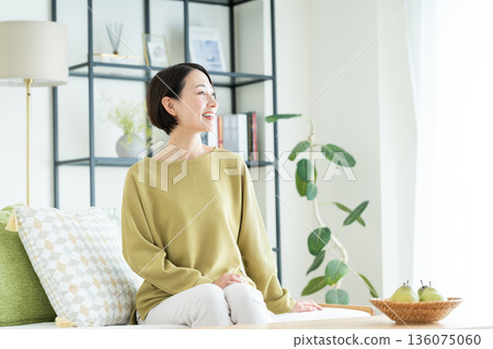 A middle-aged woman relaxing in the living room 136075060