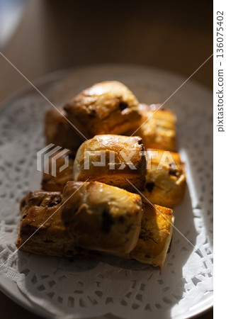 Close-up of freshly baked scones on a white plate Close-up of freshly baked scones on a white plate 136075402