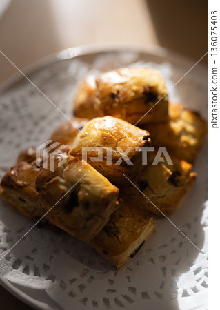 Close-up of freshly baked scones on a white plate Close-up of freshly baked scones on a white plate 136075403