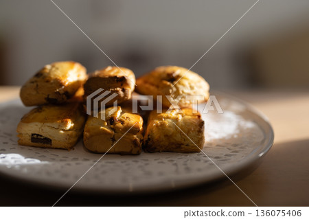 Close-up of freshly baked scones on a white plate Close-up of freshly baked scones on a white plate 136075406