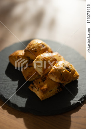 Scones on a black plate lit by natural light from a window Scones on a black plate lit by natural light from a window 136075416