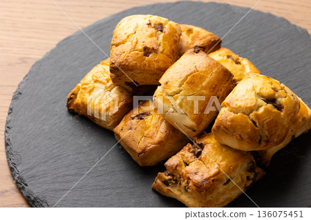 Scones on a black plate lit by natural light from a window Scones on a black plate lit by natural light from a window 136075451