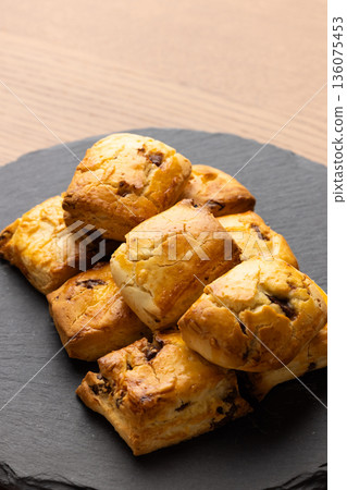 Scones on a black plate lit by natural light from a window Scones on a black plate lit by natural light from a window 136075453