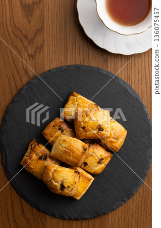 Scones and tea set on a black plate illuminated by natural light from the window Scones and tea set on a black plate illuminated by natural light from the window 136075457