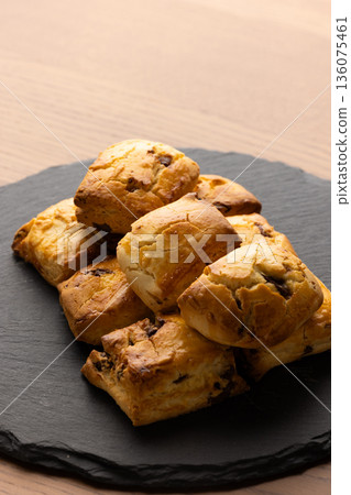Scones on a black plate lit by natural light from a window Scones on a black plate lit by natural light from a window 136075461