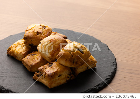 Scones on a black plate lit by natural light from a window Scones on a black plate lit by natural light from a window 136075463