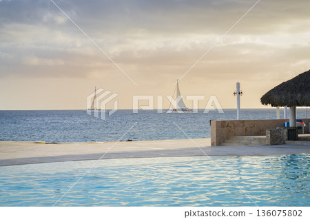 Two sailboats are racing through the Caribbean sea during sunset Two sailboats are racing through the Caribbean sea during sunset 136075802